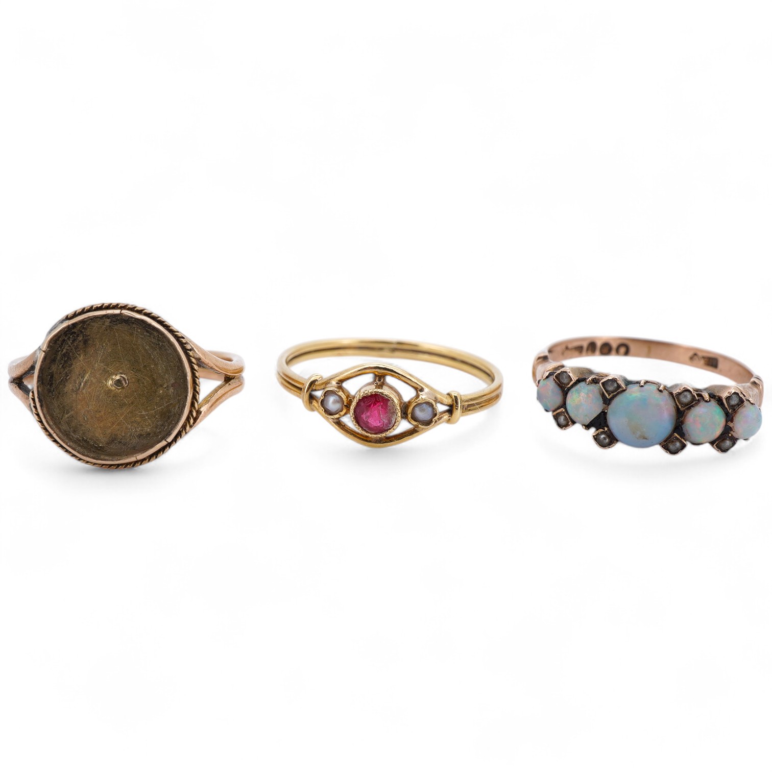 Three rings, comprising: a synthetic ruby and seed pearl ring, size O, French assay marks for 18ct gold, French maker's mark; an opal and seed pearl half-hoop ring in 9ct gold, size M1/2, British hallmarks; and a gold ri